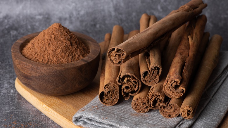 cinnamon sticks beside a bowl of ground cinnamon