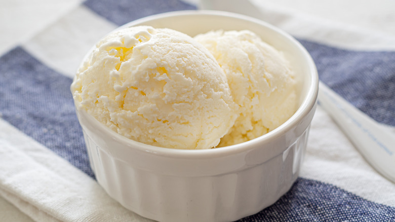 Cup of vanilla ice cream on blue and white napkin