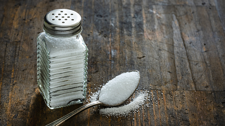Glass salt shaker on a wooden table
