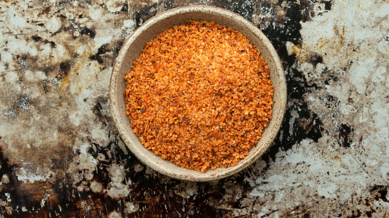 Bowl of Tajín seasoning on marble counter