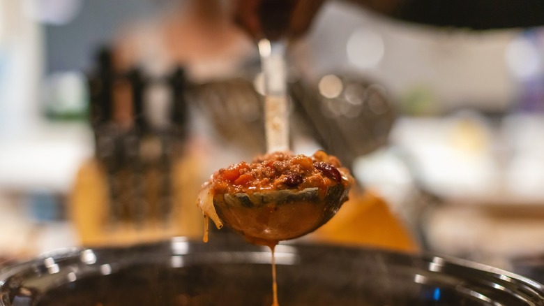 spoon of chili over pot