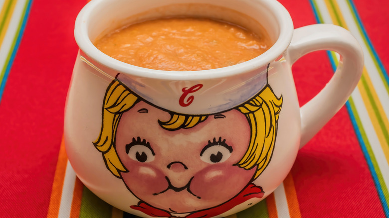 A soup bowl bearing the face of the iconic Campbell's kid is filled with tomato soup