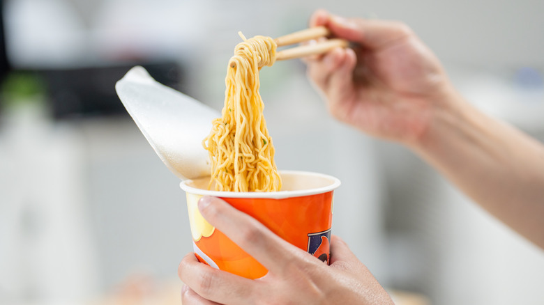 Ramen held in chopsticks.