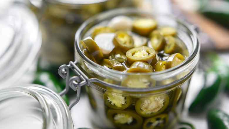 A jar of pickled jalapeños in brine.