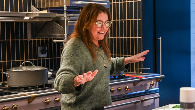 Food Network host Rachel Ray stands in a kitchen set