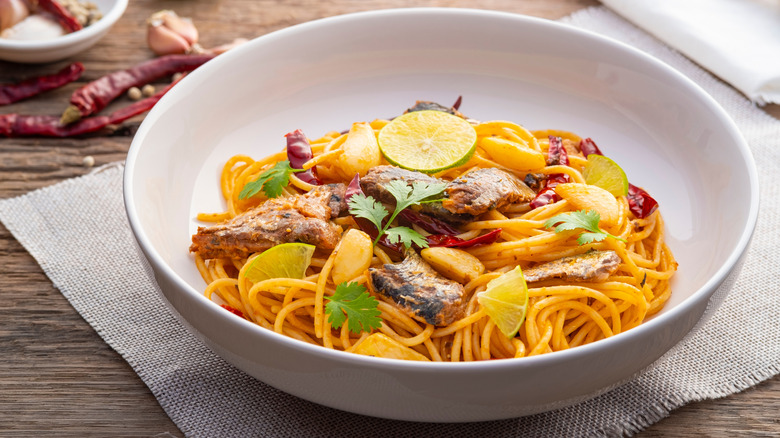 Bowl of vibrantly colored spaghetti made with canned mackerel, chiles, citrus, and herbs