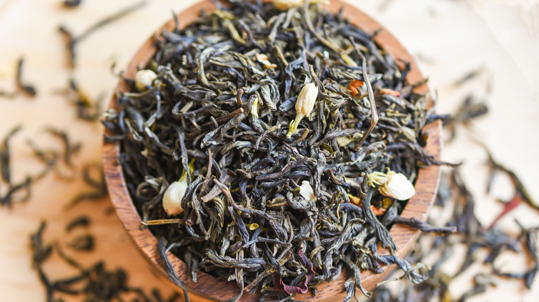Dried tea leaves in a wooden bowl