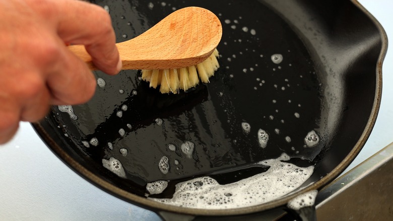 Person washing a cast iron skillet