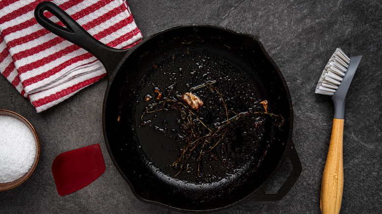 cast iron pan full of oil and salt with scrub brush