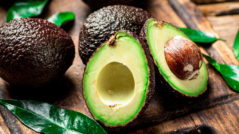 Halved and whole avocados