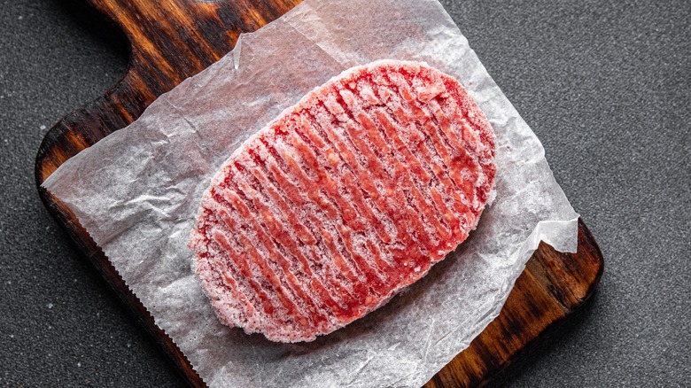 Frozen meat on wooden slab