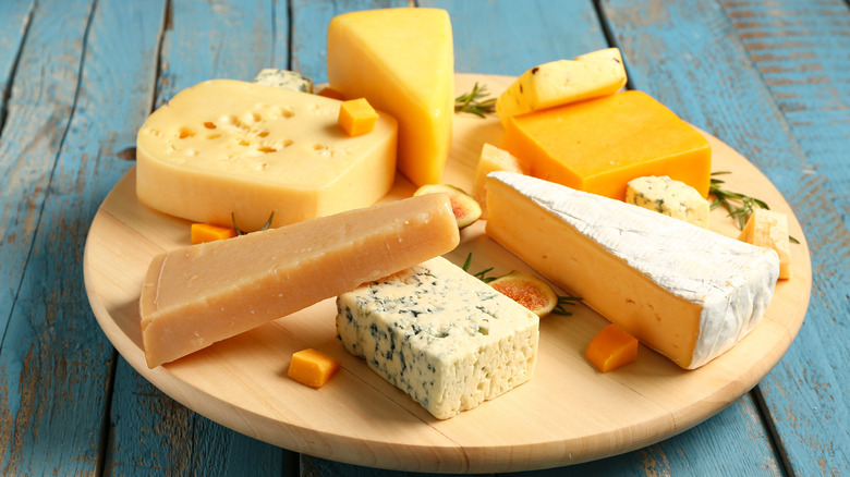 A variety of cheeses on a wooden board