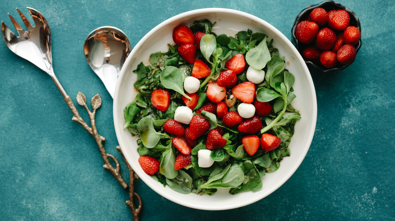 Leafy salad with strawberries in a bowl