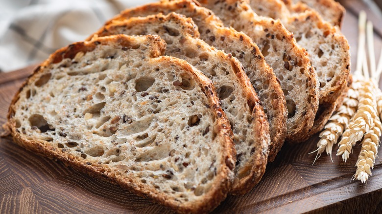 Slices of multigrain sourdough bread and sprigs of wheat