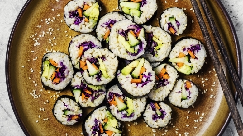 Plate of vegetarian sushi rolls with chopsticks