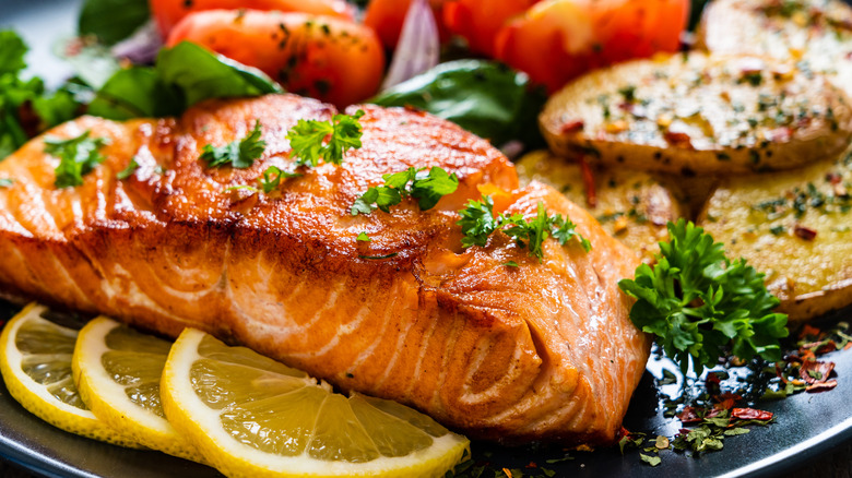 cooked salmon with lemon and herbs on top
