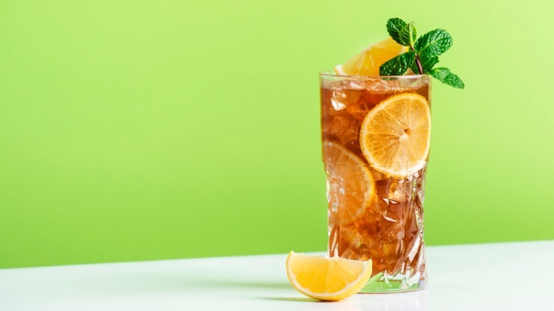 Long island iced tea cocktail on a green background 