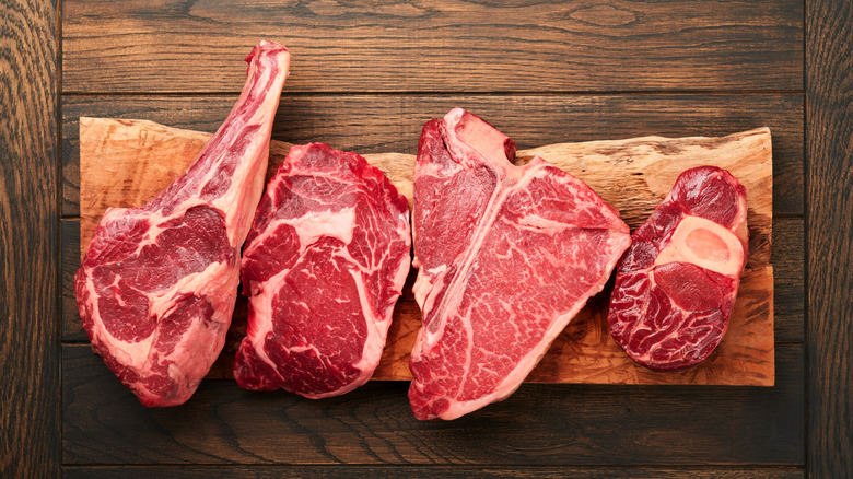 A variety of steaks on a board including ribeye and sirloin