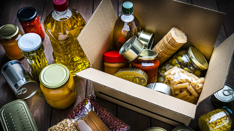 Cardboard box filled with a variety of canned and jarred foods