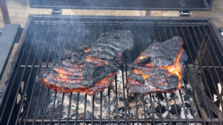 A slab of burned ribs on the grill