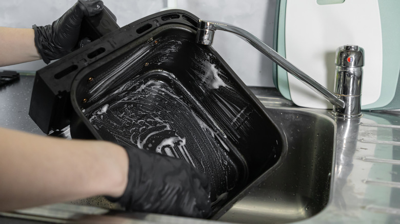 Cleaning an air fryer basket in the sink