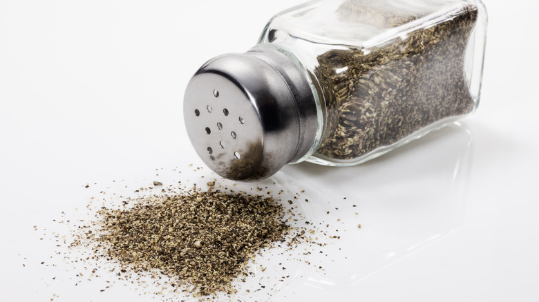 A black pepper shaker with pepper powder