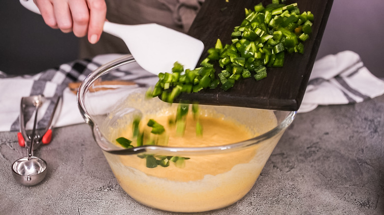 Putting chopped jalapenos into cornbread batter