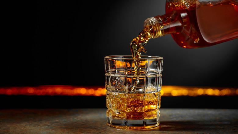 Whiskey being poured into a crystal glass.