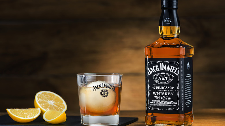 A bottle of Jack Daniel's sits next to an iced glass of Jack.