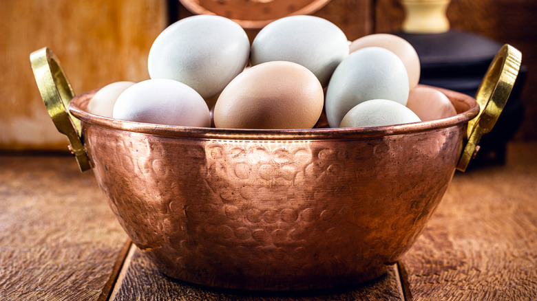 Eggs stacked in copper bowl