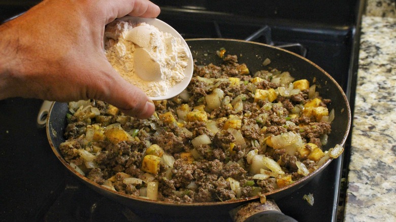 adding flour to the pan