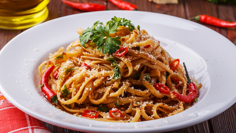 Pasta all'arrabbiata with red chili pieces and chiles in a round dish