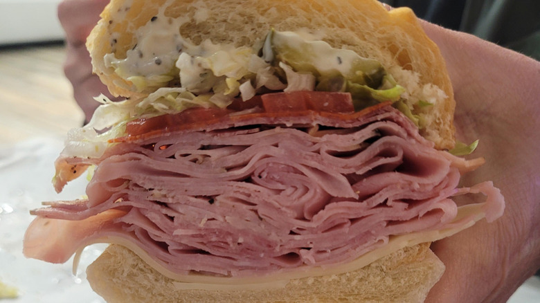 A hand holding a Classic Italian sub from Jersey Mike's