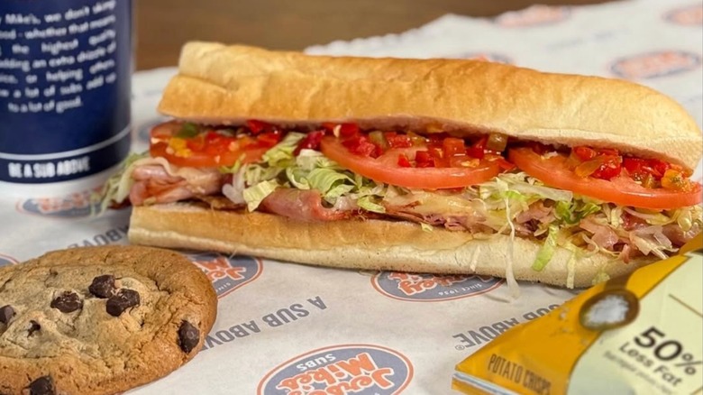 Jersey Mike's Mike's Hot Italian Sub on a table with a cookie and bag of chips