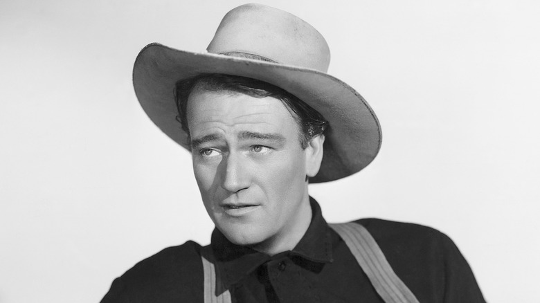 A young John Wayne wearing a cocked cowboy hat