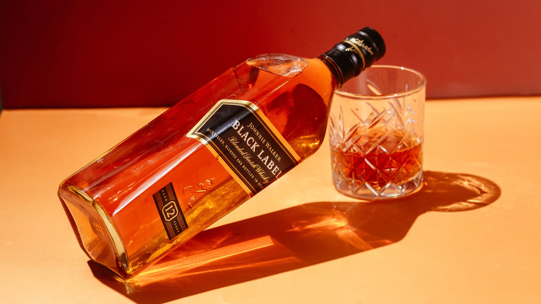 Johnnie Walker Black Label bottle resting on a whisky glass.