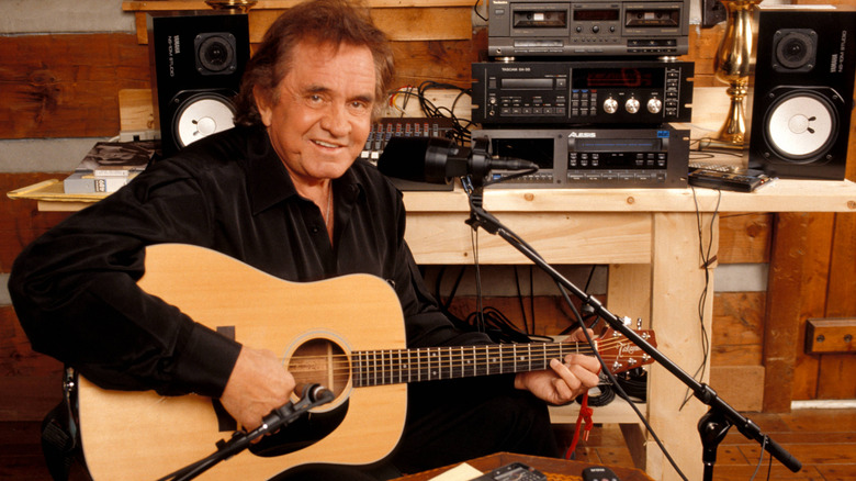 Johnny Cash sitting in a studio with a guitar