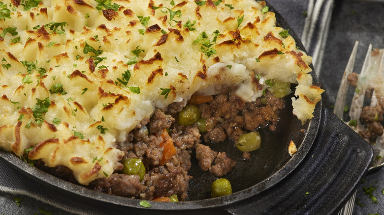 A modern shepherd's pie with peas and carrots.