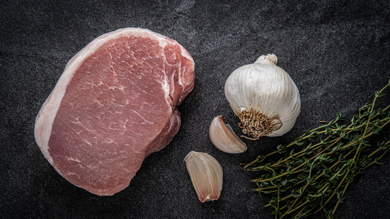 Center cut pork chop displayed on a cutting board.