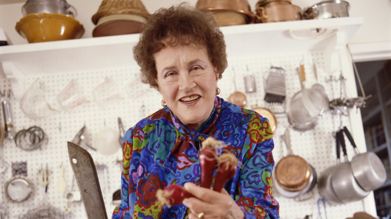 Julia Child holding carrots and a knife