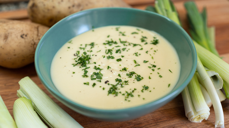 Cold vichyssoise soup surrounded by its ingredients