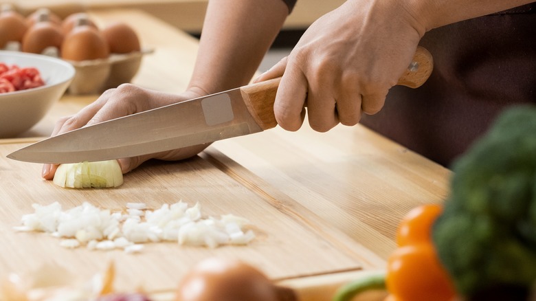 Woman chopping white onion