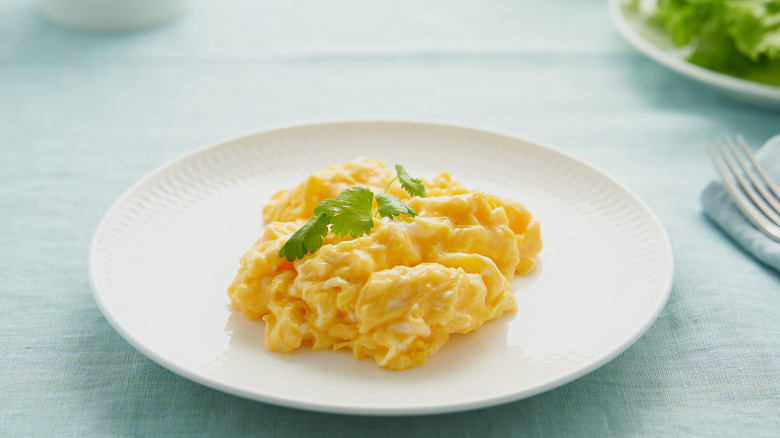 Soft scrambled eggs on white plate