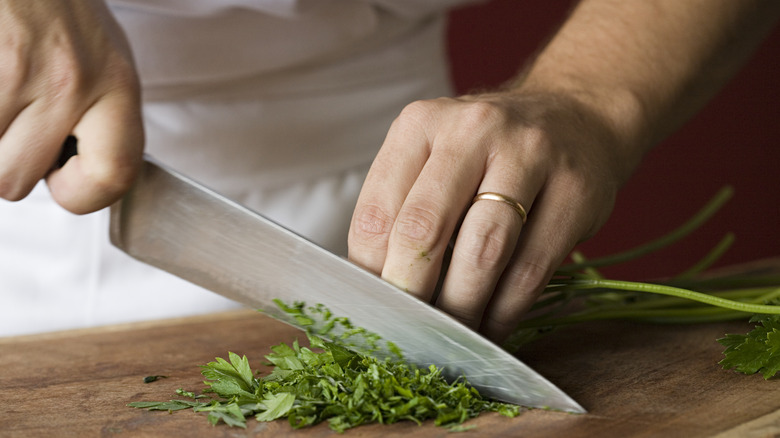 chef cutting on wooden cutting board