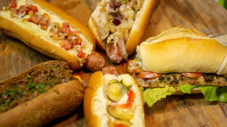 Different types of hot dogs on a wooden cutting board