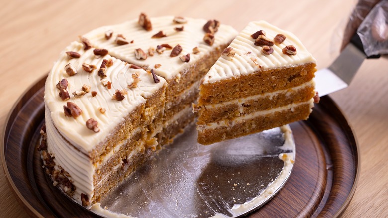 Person serving slices of cut carrot cake