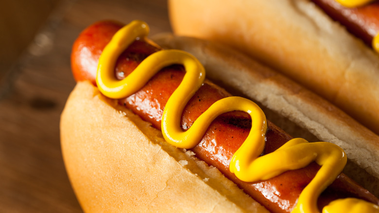 Grilled hot dog in bun with mustard