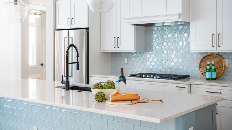 A clean, shiny white and light blue kitchen