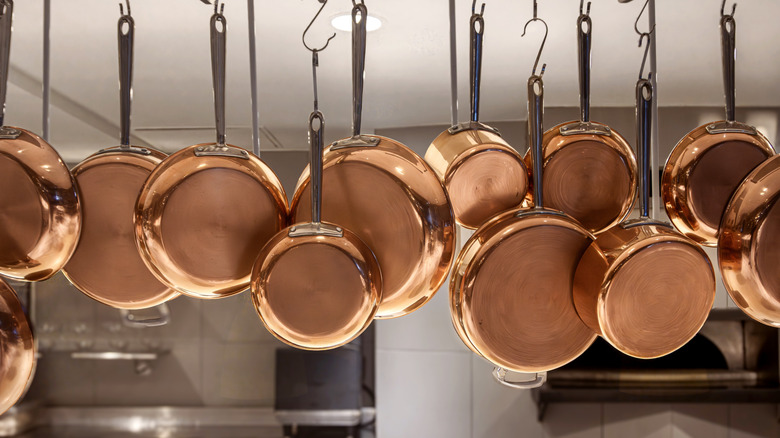 Clean, shining copper pans hanging from the ceiling