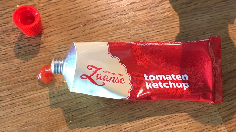 Tubed ketchup on a wooden surface.